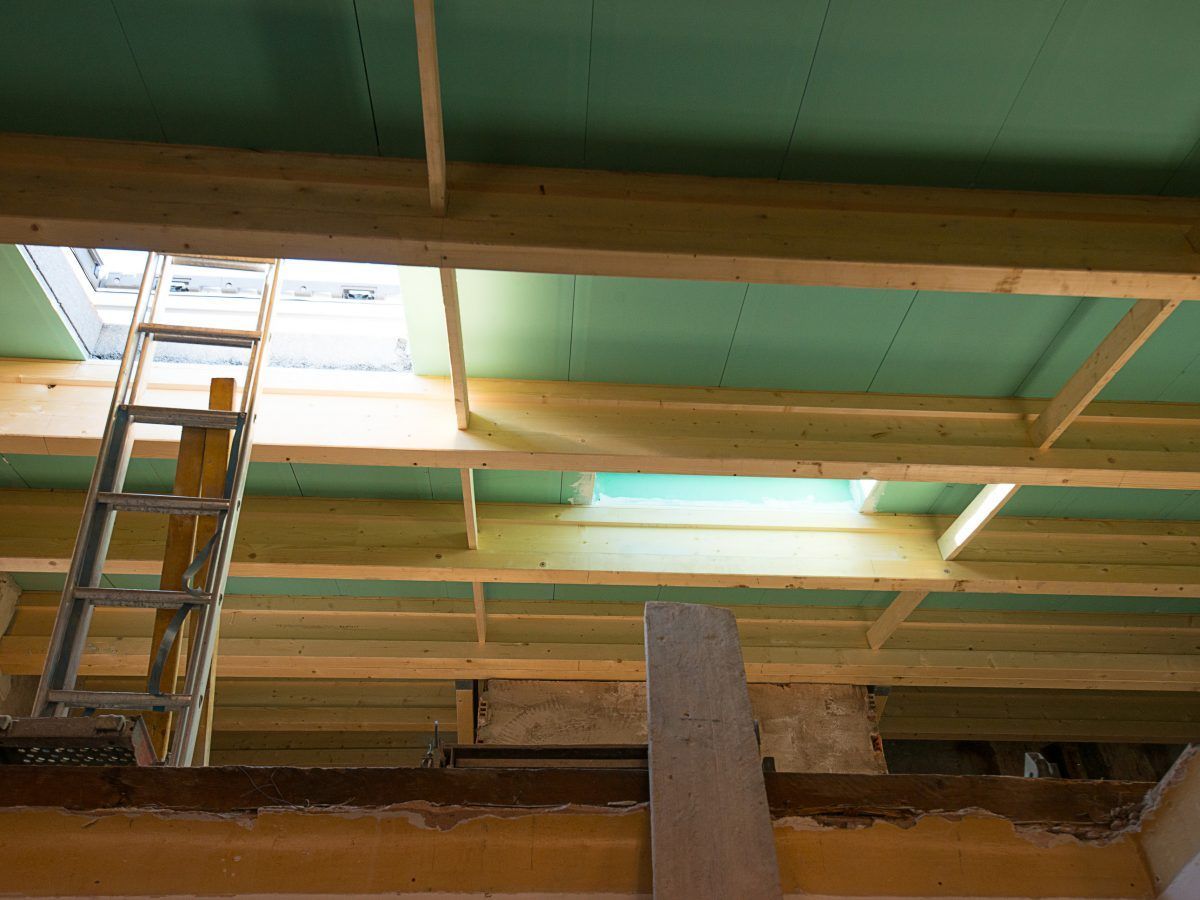 Échelle permettant d'accéder à une lucarne dans un plafond en bois en construction