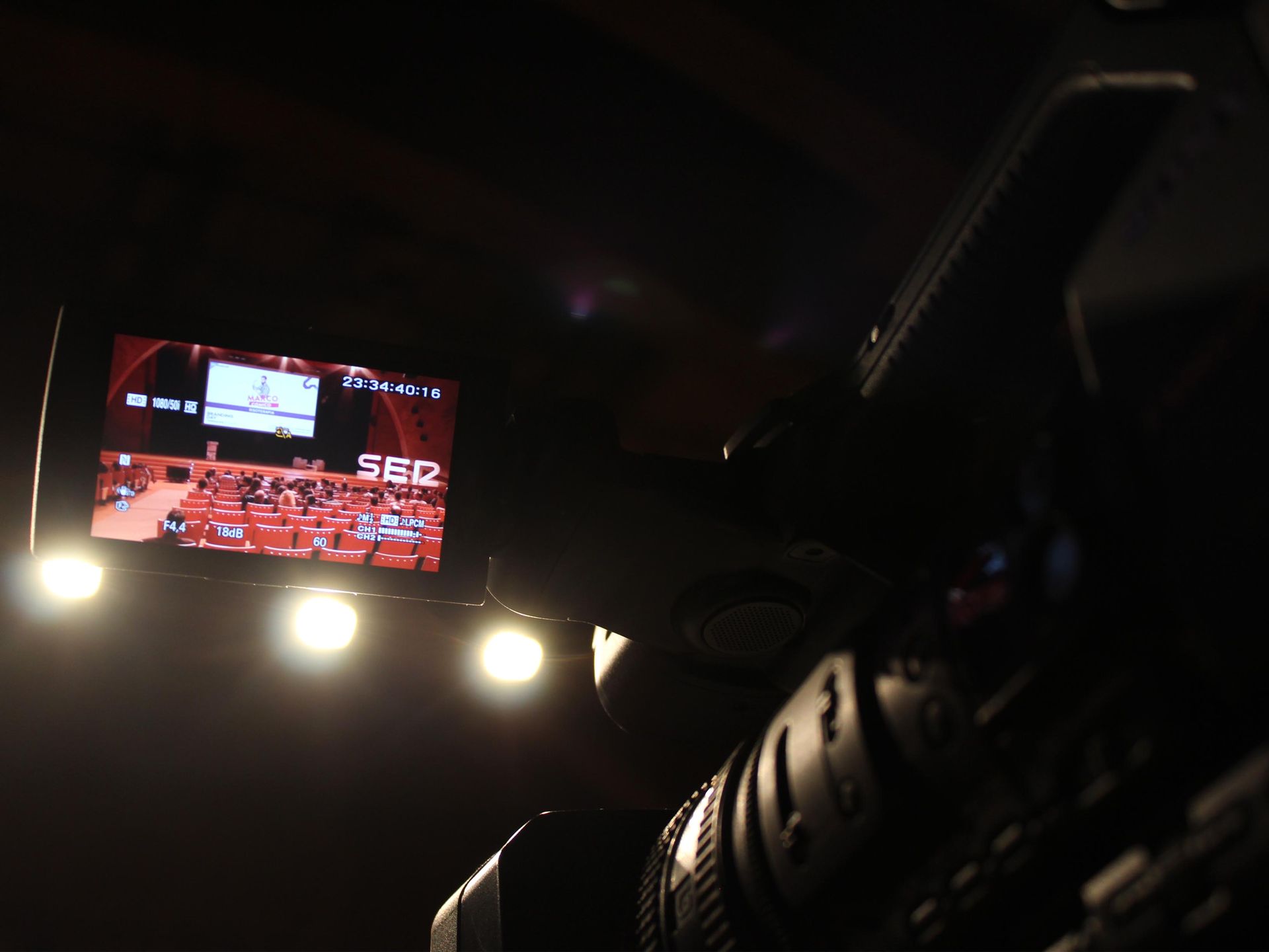 Una cámara está tomando una fotografía de un auditorio con el número 562 en la pantalla.