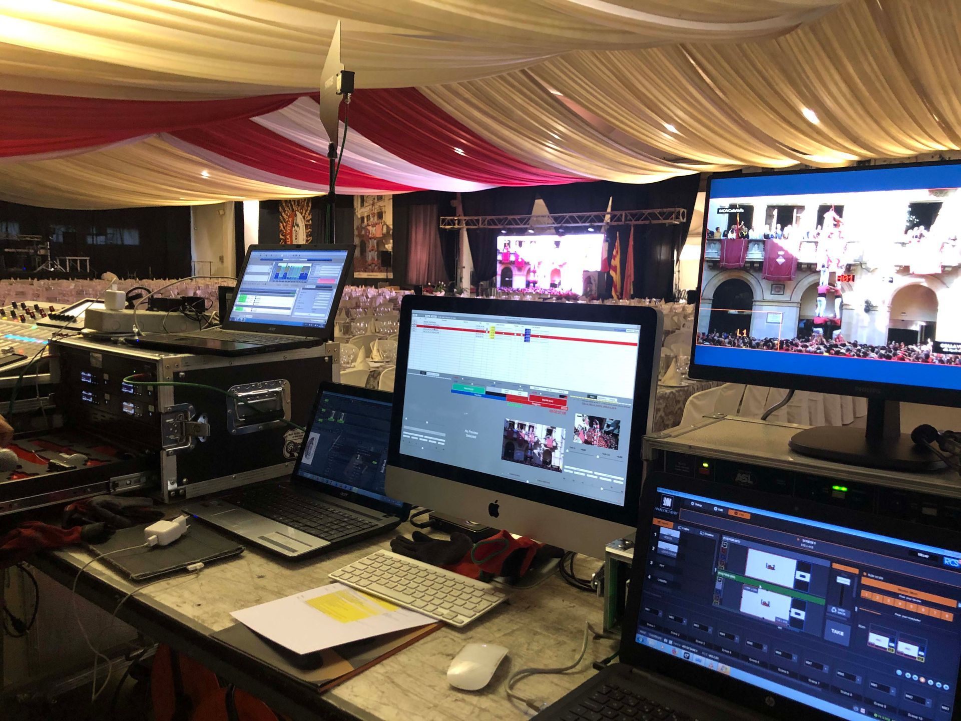 Una habitación con muchos ordenadores y portátiles sobre una mesa.