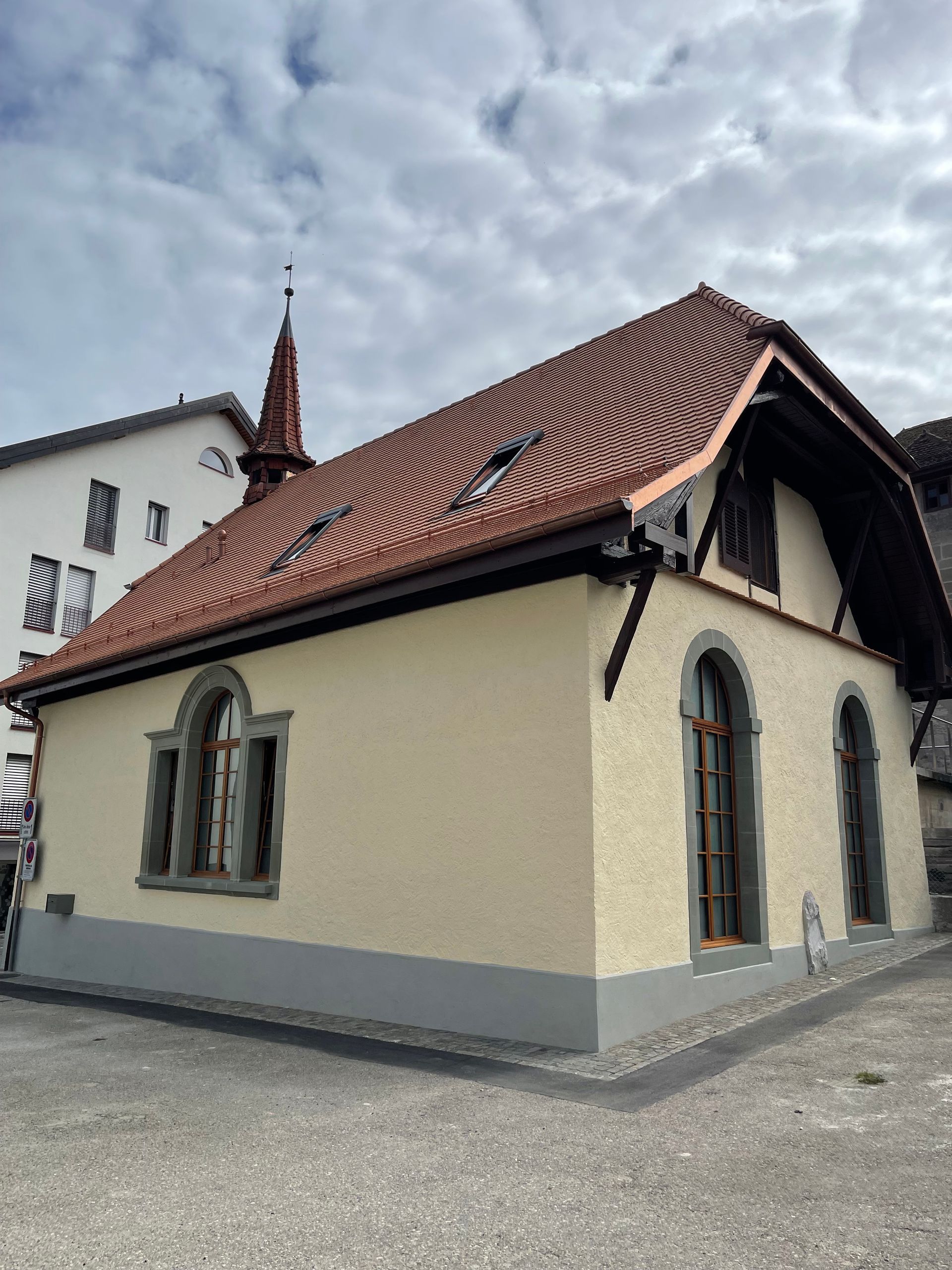 Mur carrelé orné d'un motif répétitif de losanges orange et de fleurs de lys argentées.