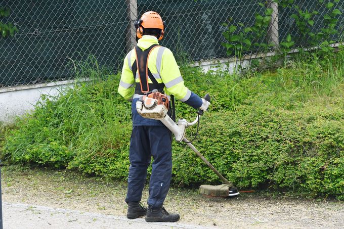 Une personne tenant une débroussailleuse