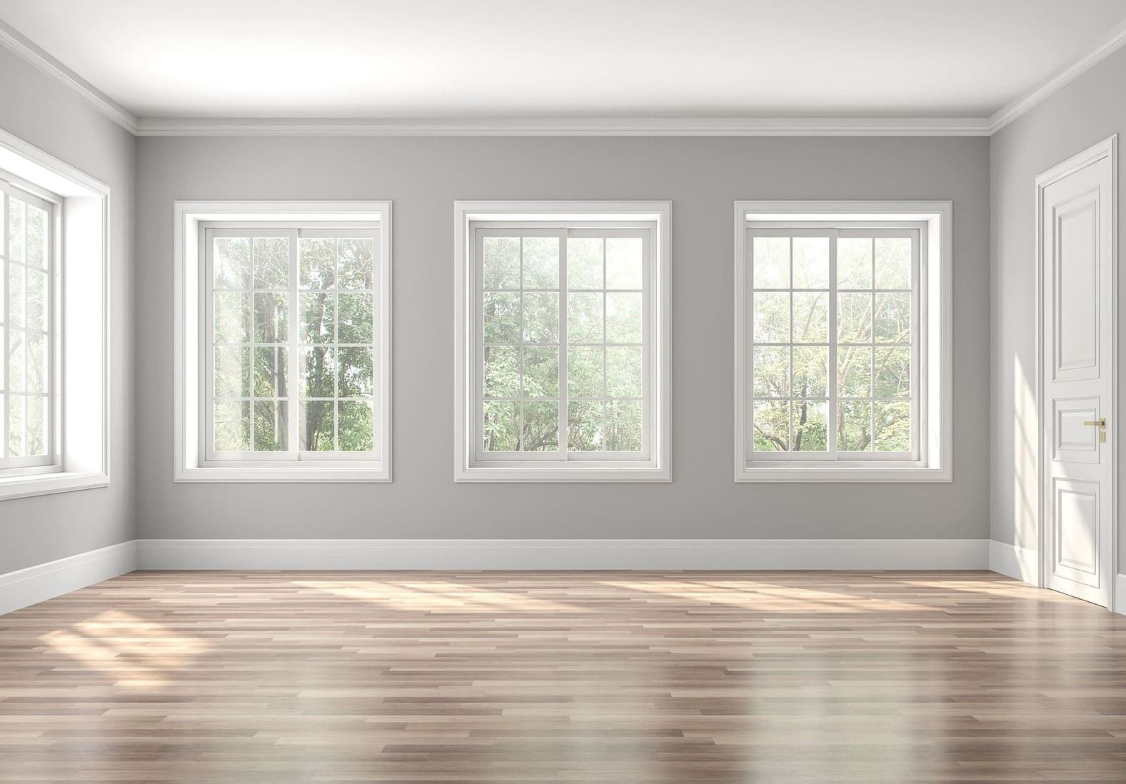 Una habitación vacía con tres ventanas y suelo de madera.