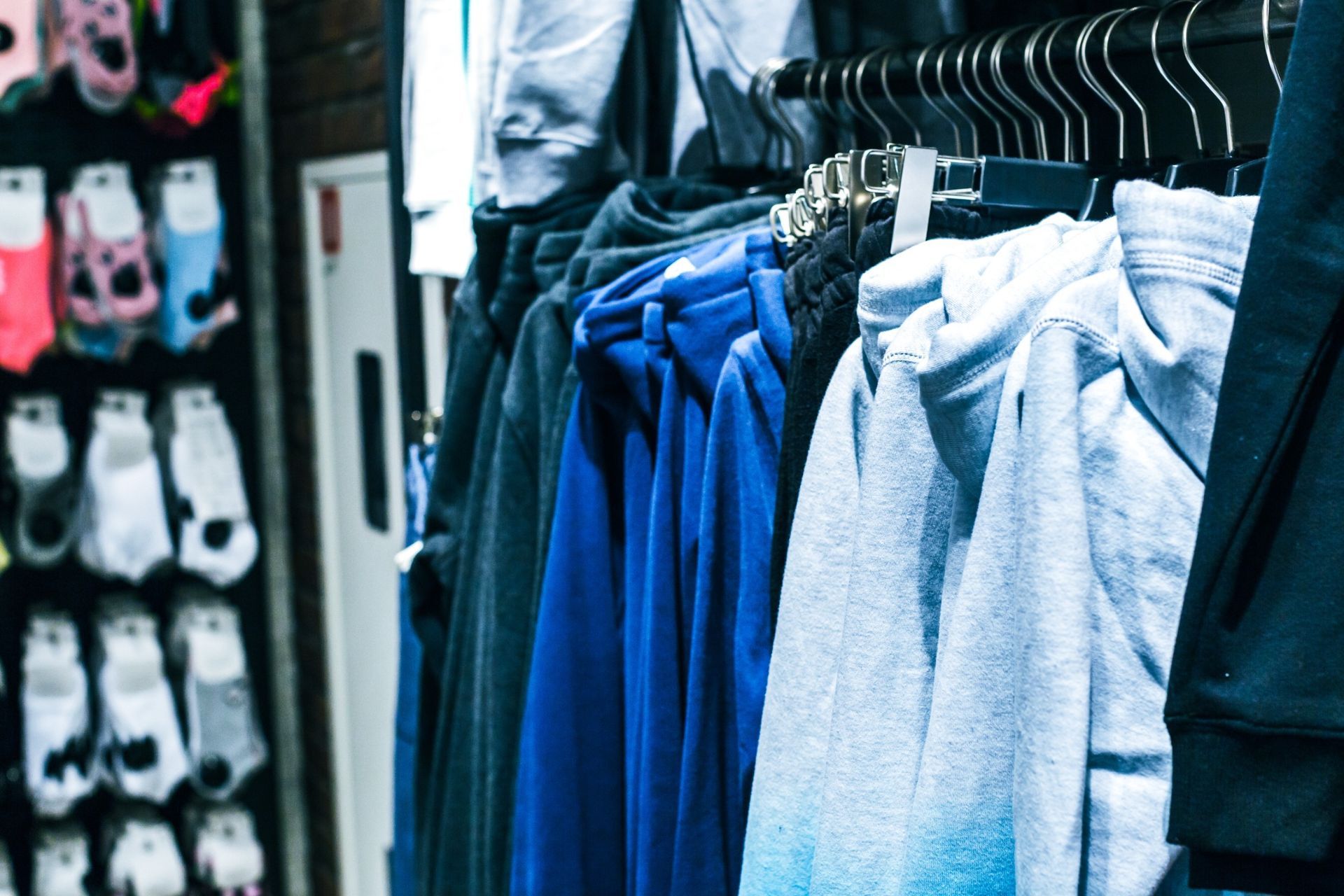 Un montón de ropa está colgada en un perchero en una tienda.