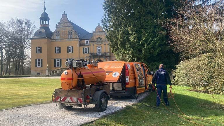 Breideneichen GmbH - Entsorgungsfachbetrieb Ein Mann steht neben einem Tanklastwagen vor einem Schloss.