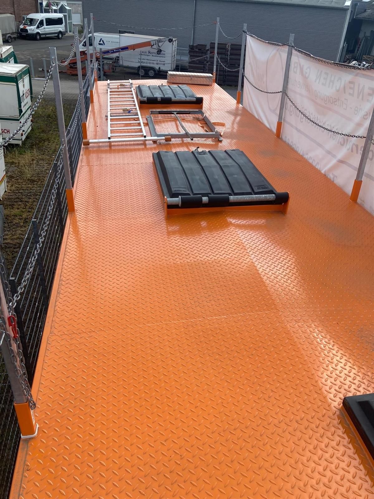 Ein großer orangefarbener Tisch mit einer Leiter darauf.