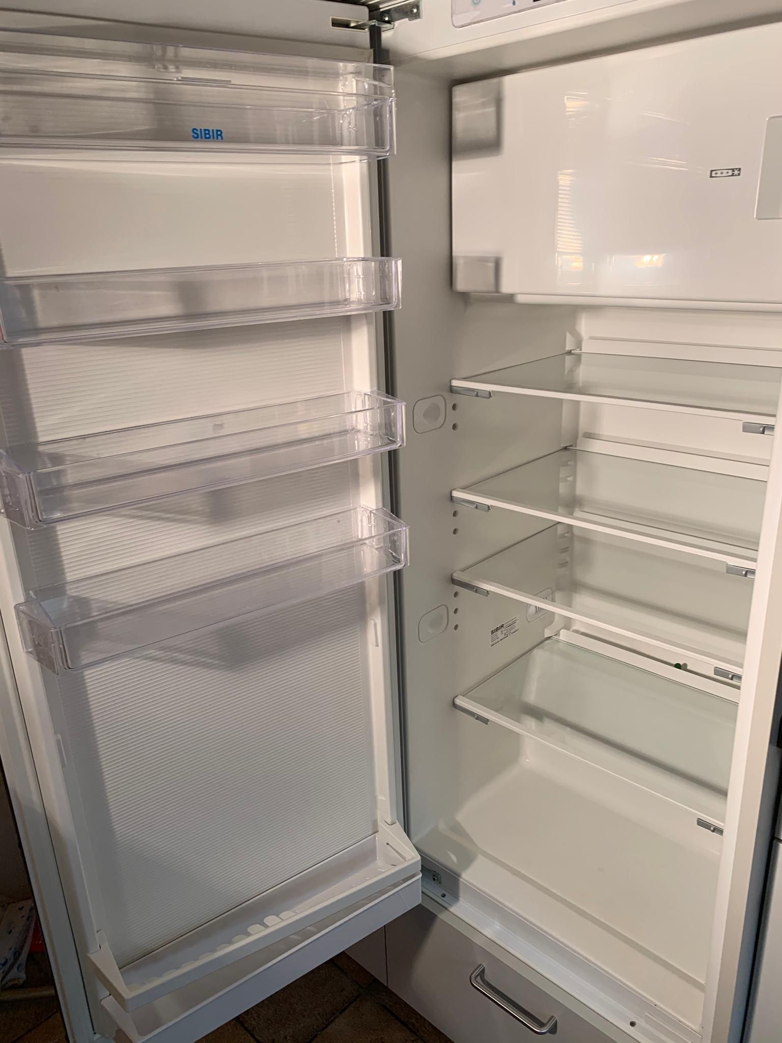 L'intérieur d'un réfrigérateur vide propre avec la porte ouverte.