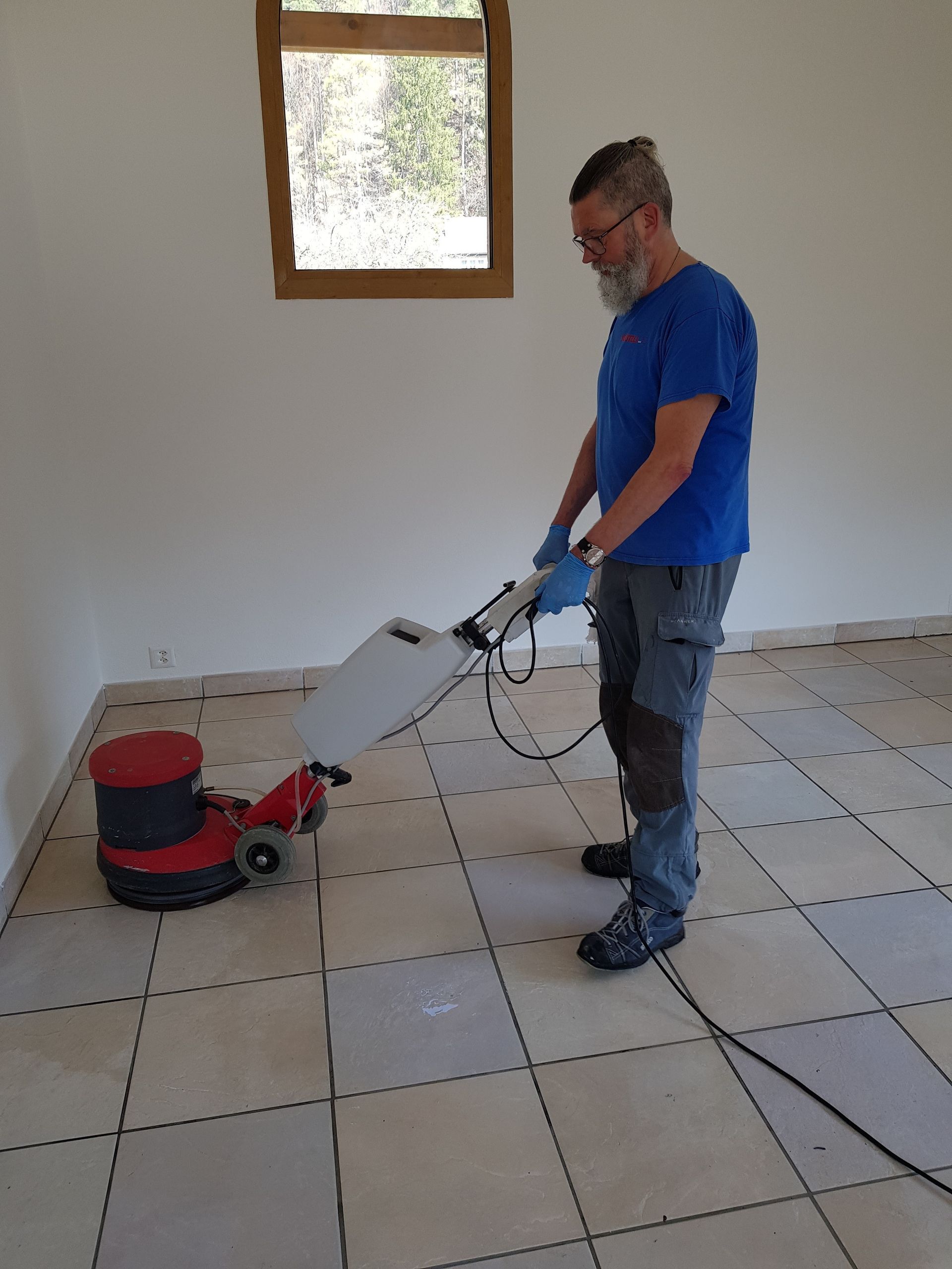 Une personne portant des gants jaunes nettoie une cuisinière avec une éponge.