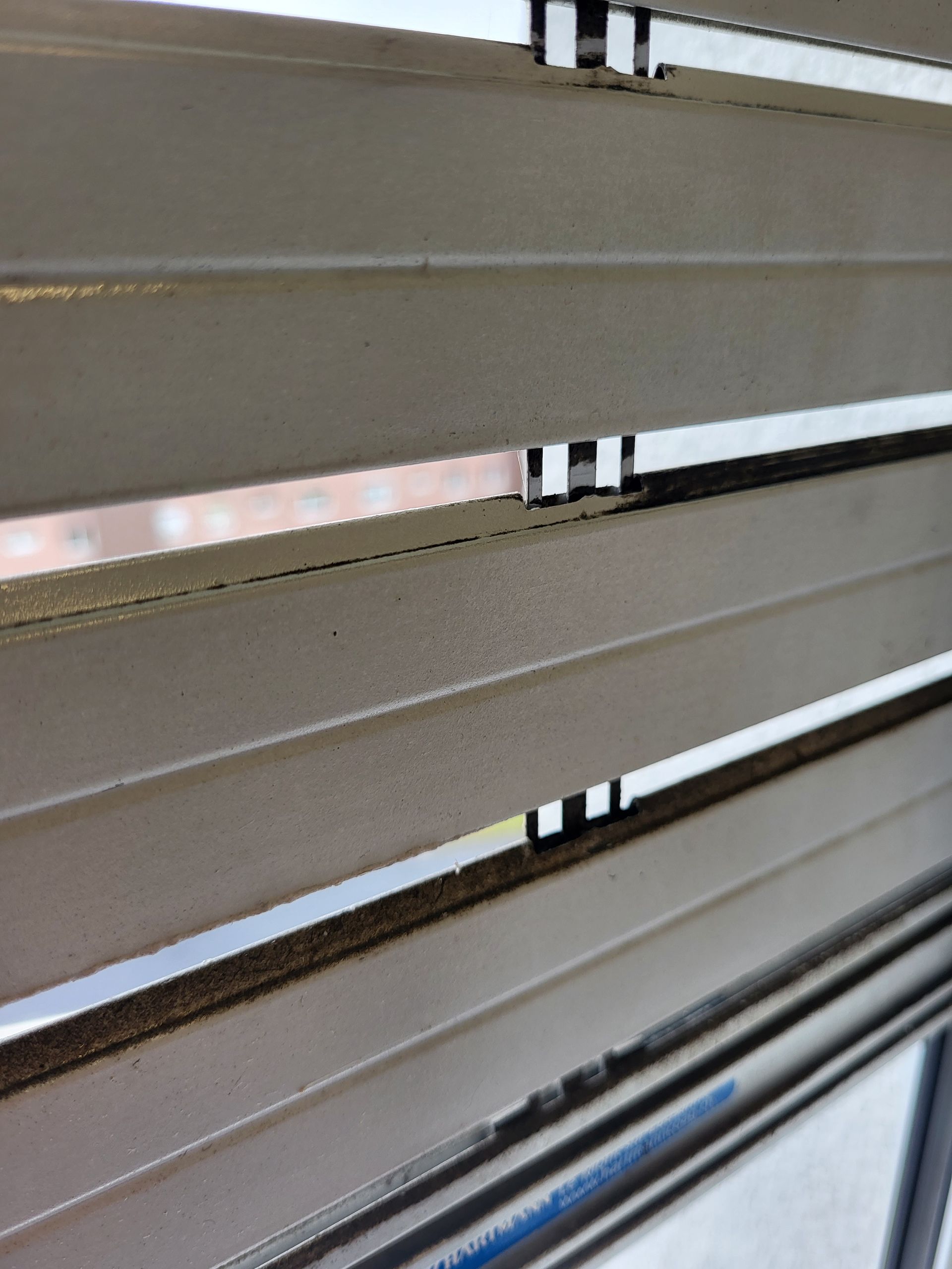 Un gros plan d'une fenêtre avec des stores  nettoyés dessus.