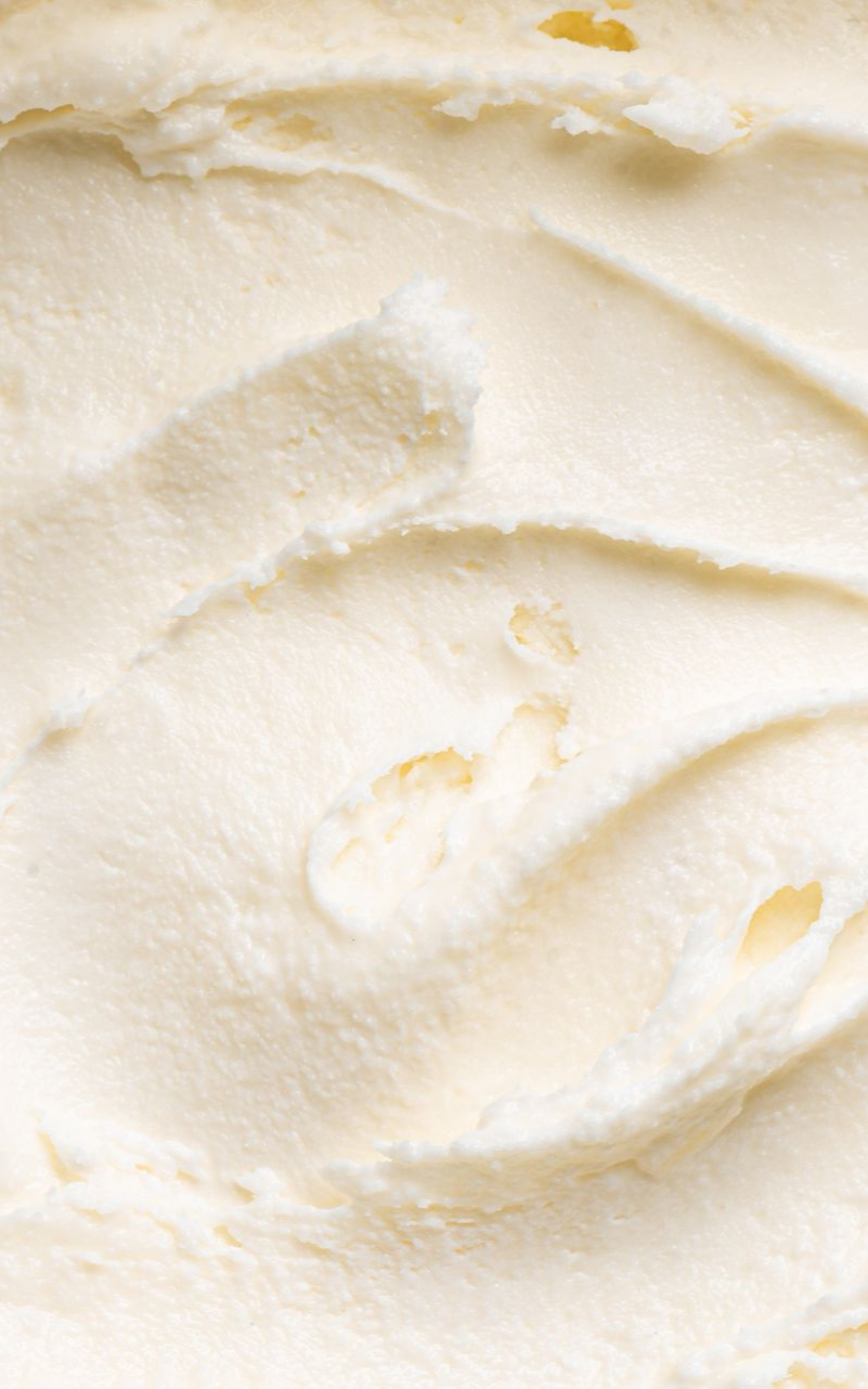 Gros plan sur un tourbillon de substance crémeuse, texturée et blanc cassé.