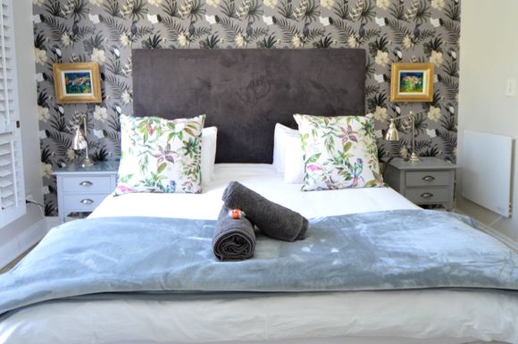 De Medici Sandton Accommodation Bedroom with patterned wallpaper, king bed