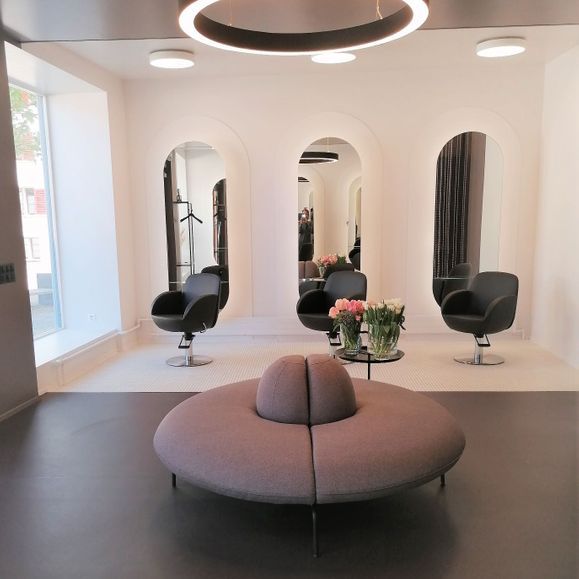 Ein Wartezimmer mit runder Couch und Stühlen