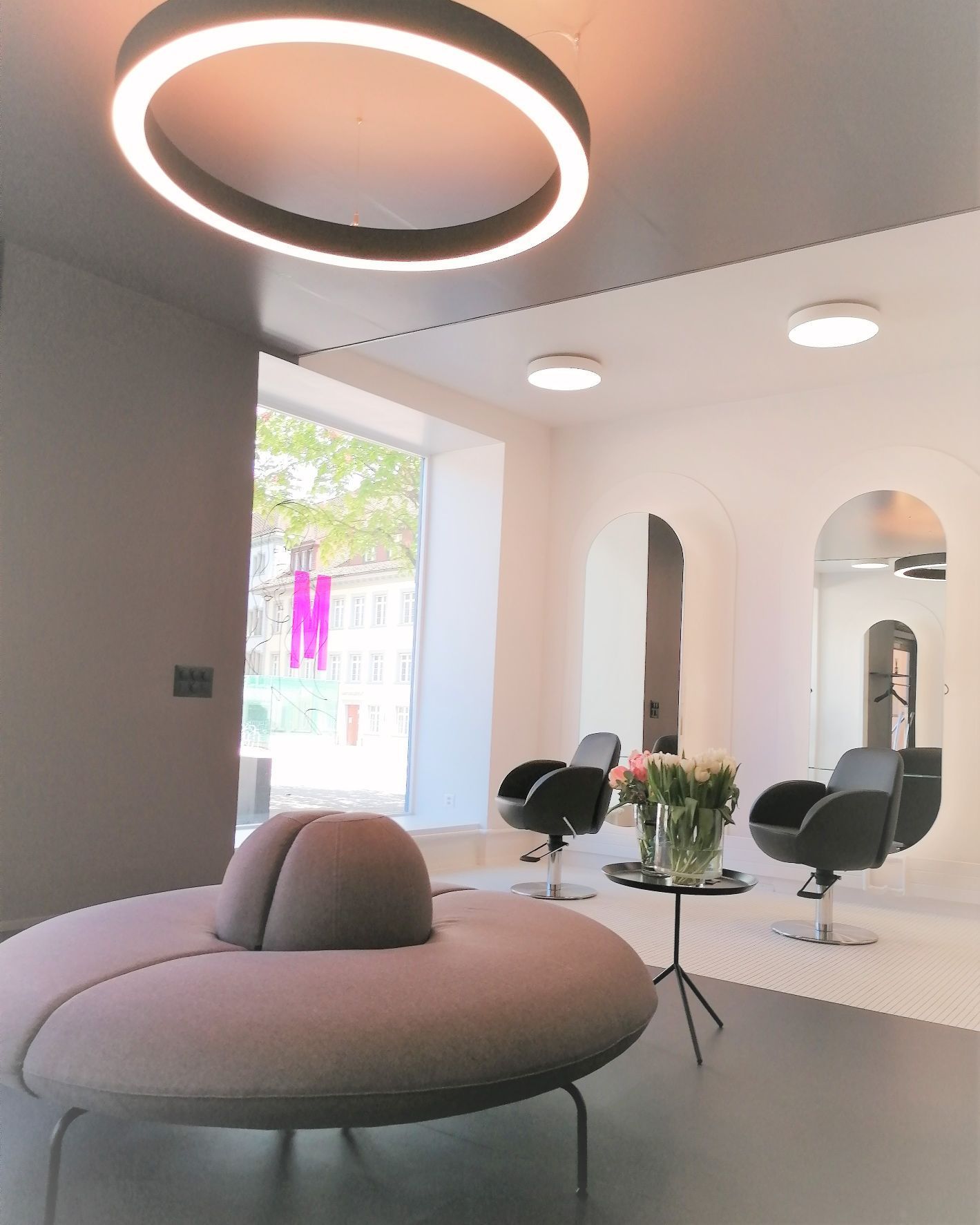 Ein Wartezimmer mit runder Couch und Stühlen