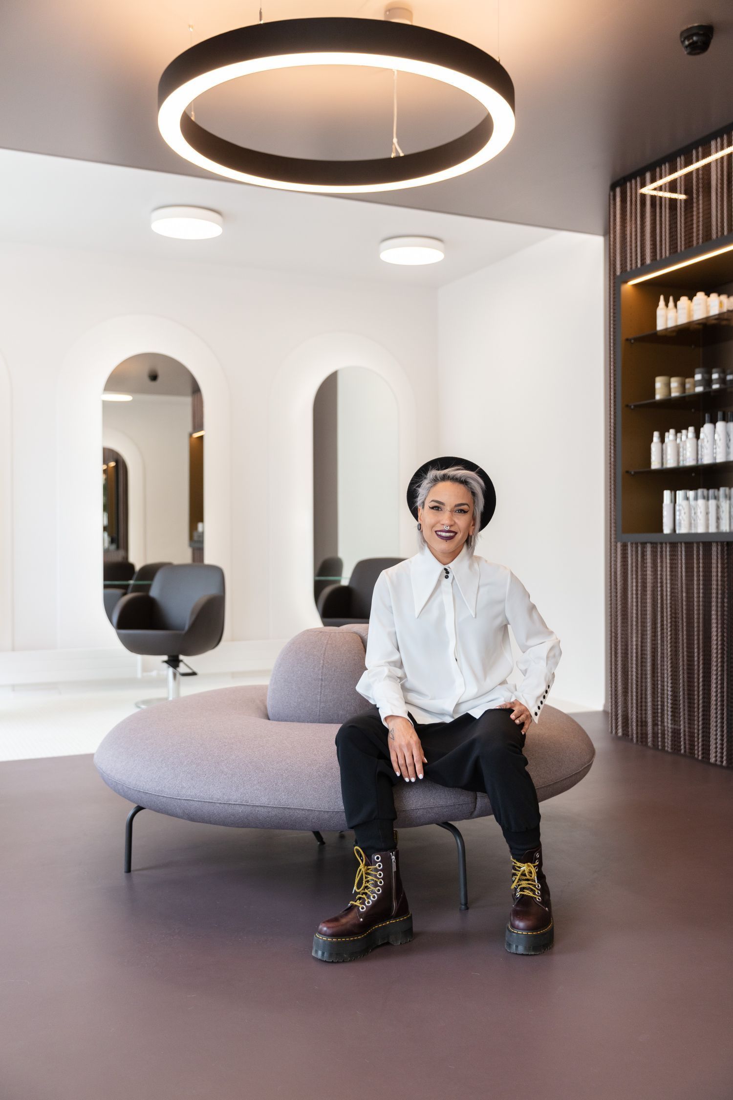 Eine Frau sitzt auf einer Couch in einem Salon.