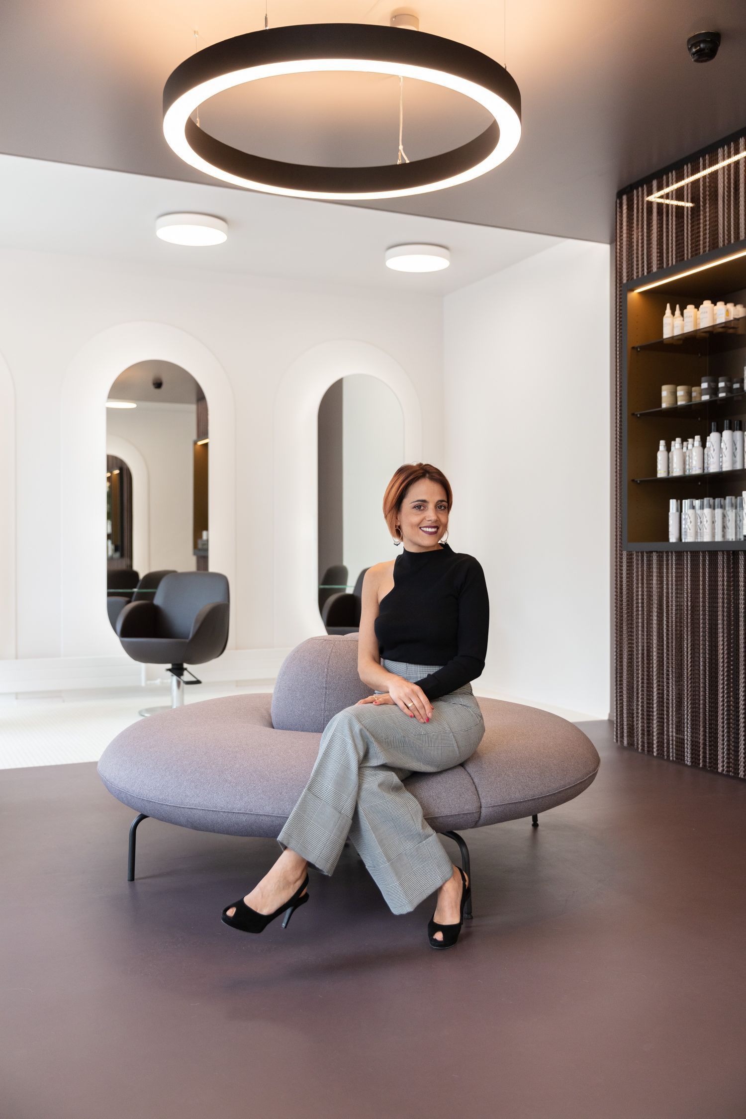 Eine Frau sitzt auf einer Couch in einem Salon.