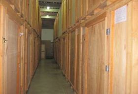 Un largo pasillo lleno de cajas de madera en un almacén.