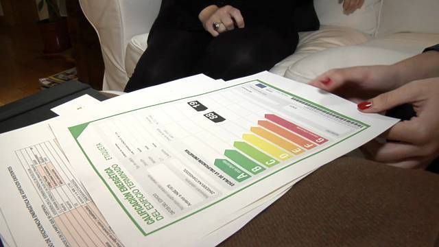 Una mujer sostiene un trozo de papel que dice eficiencia energética.