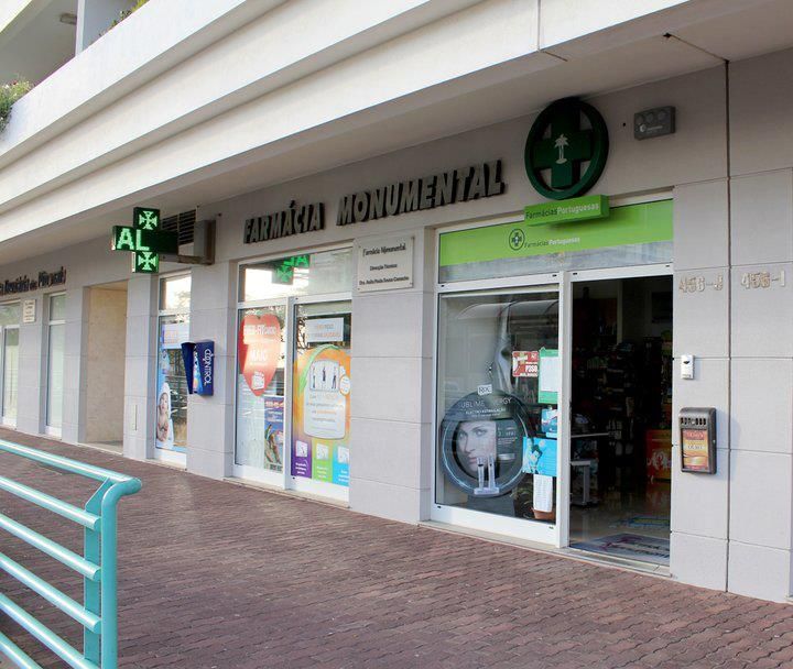 Uma farmácia com uma placa verde que diz 'clinica monumental'