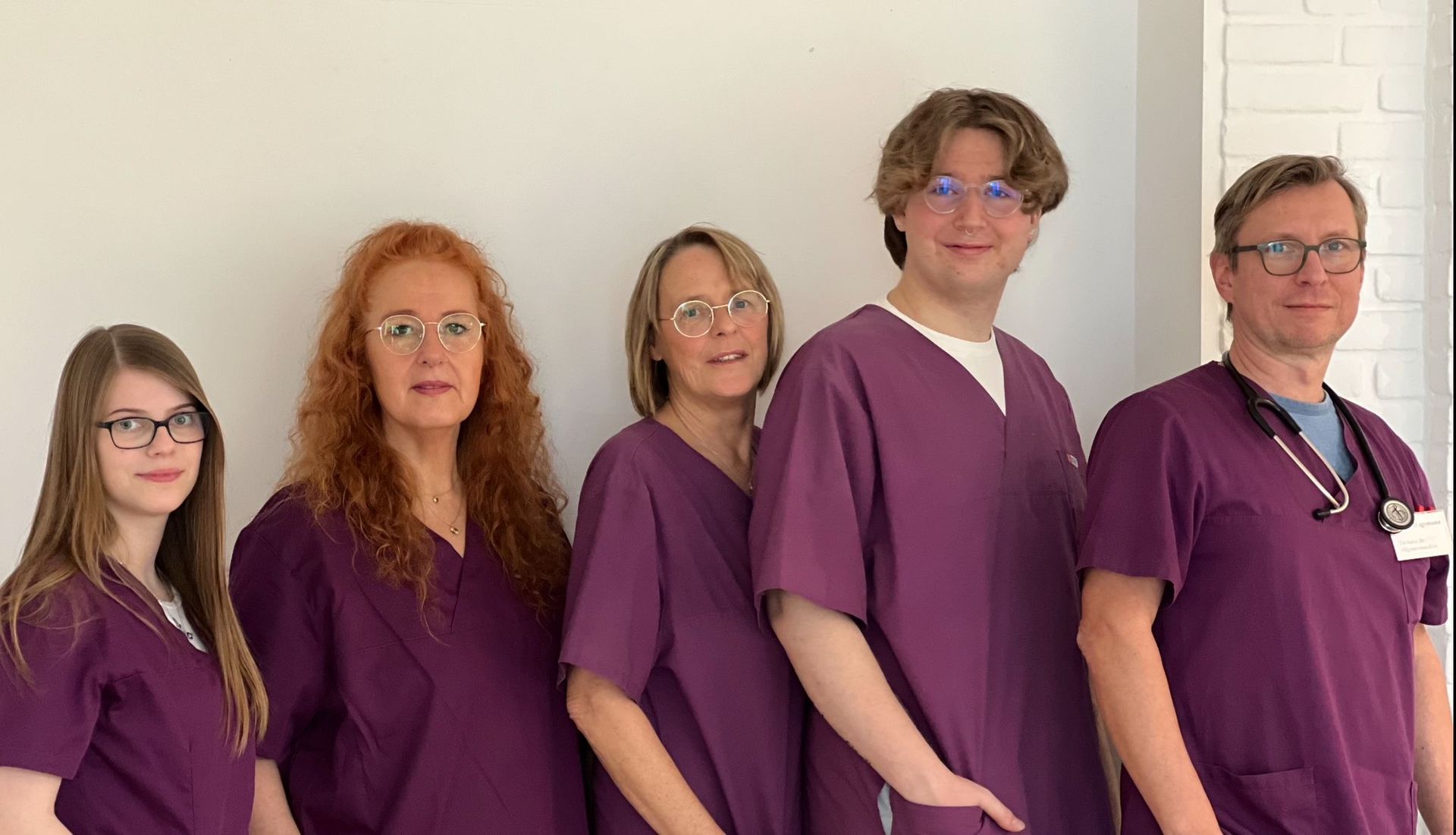 Hausarzt Rainer Hagemann und das Team, posen seitlich vor der Kamera. Hausarzt Rainer Hagemann und das Team, posen seitlich vor der Kamera.