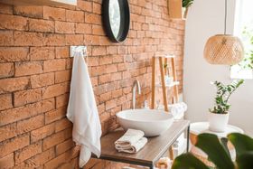 Un baño con una pared de ladrillo y un lavabo.