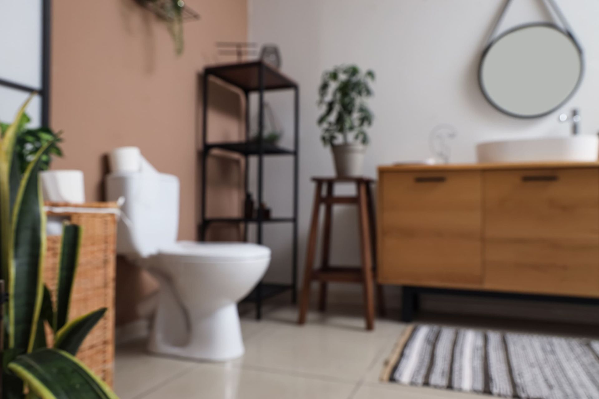 Un baño con inodoro, lavabo, espejo y plantas.