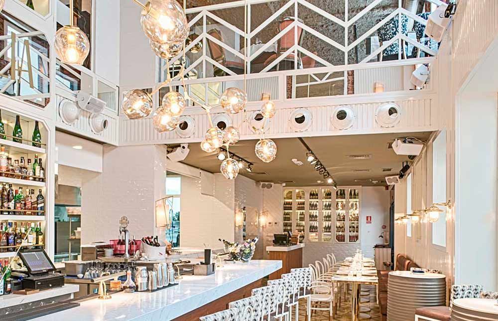 Un restaurante con una barra larga y mesas y sillas.
