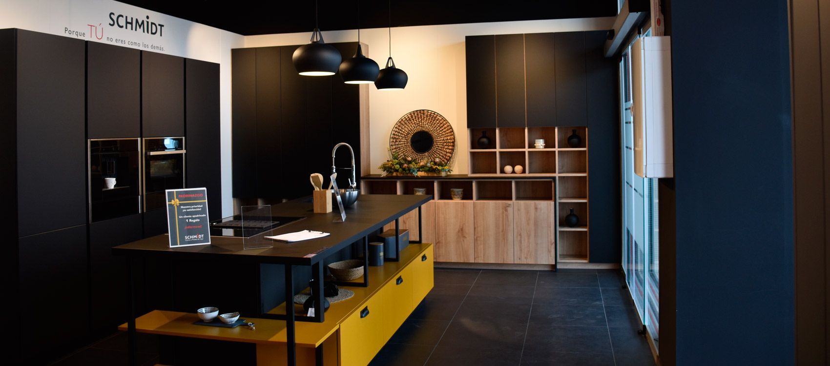 Una cocina con gabinetes negros y amarillos y una gran isla en el medio.