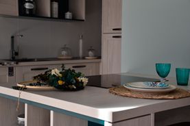 Una cocina con una mesa con platos y vasos encima.