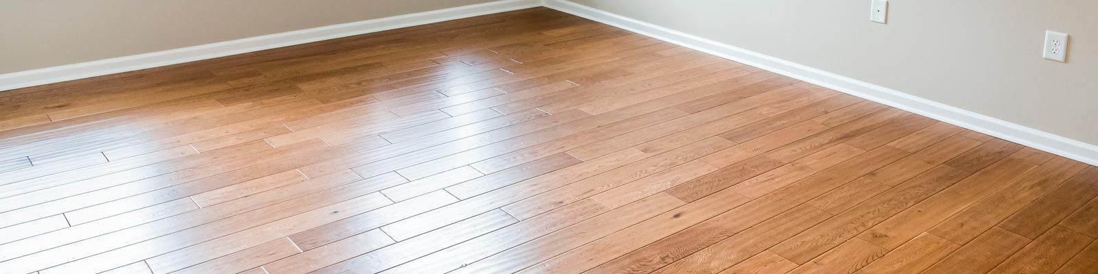 Una habitación con pisos de madera y una ventana con persianas.
