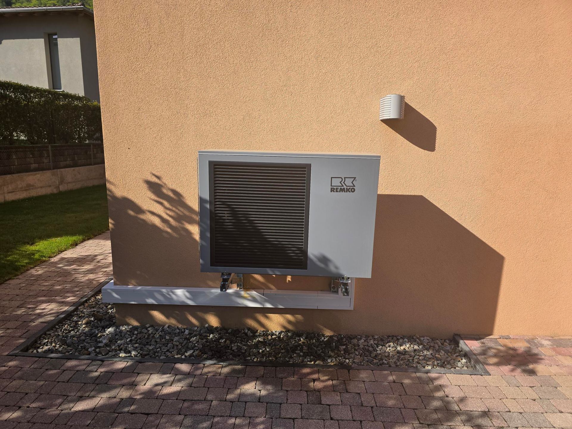 Un uomo sta lavorando su un condizionatore d'aria all'esterno di un edificio.