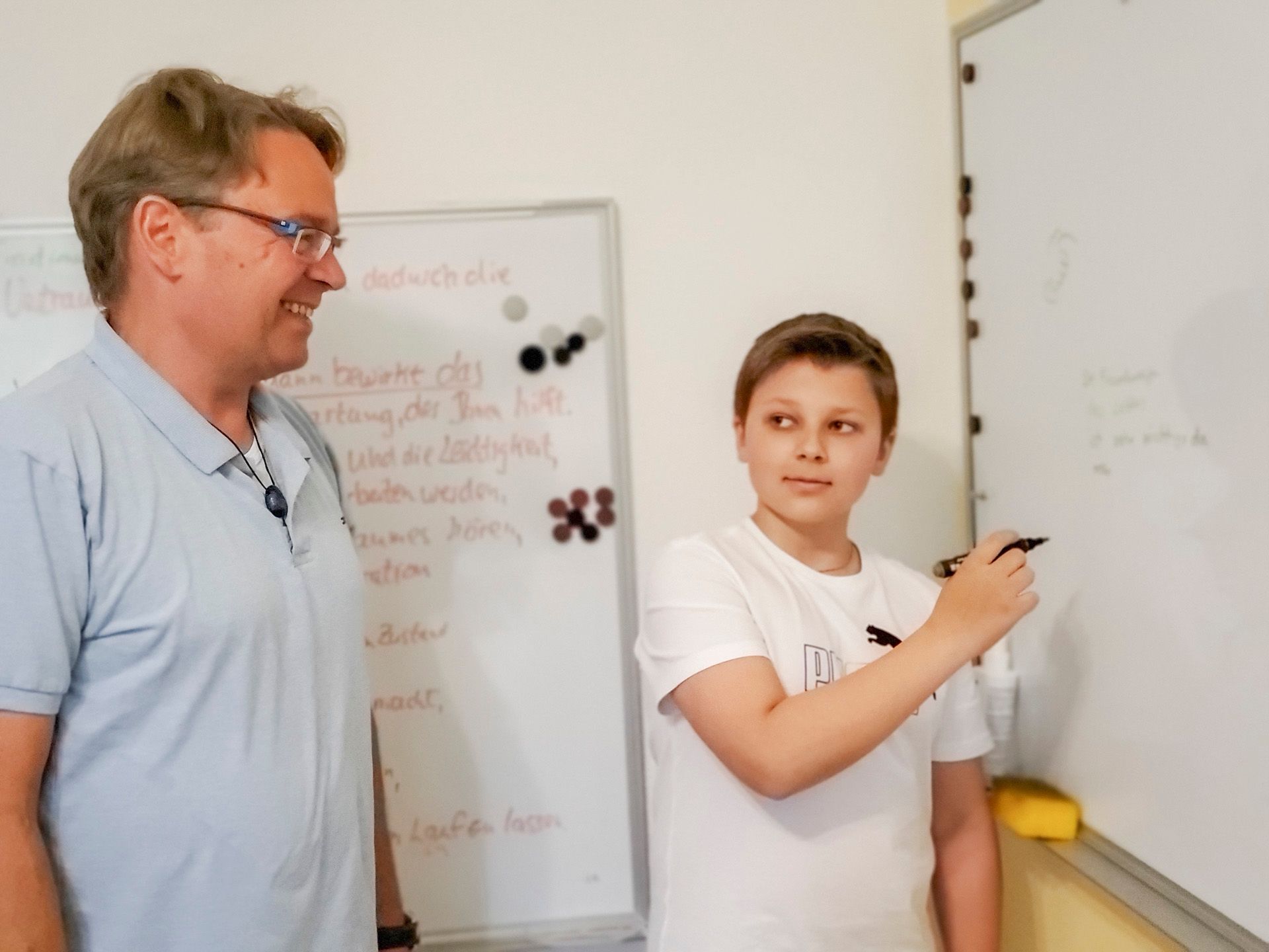 Ein Mann und ein Junge stehen vor einer weißen Tafel