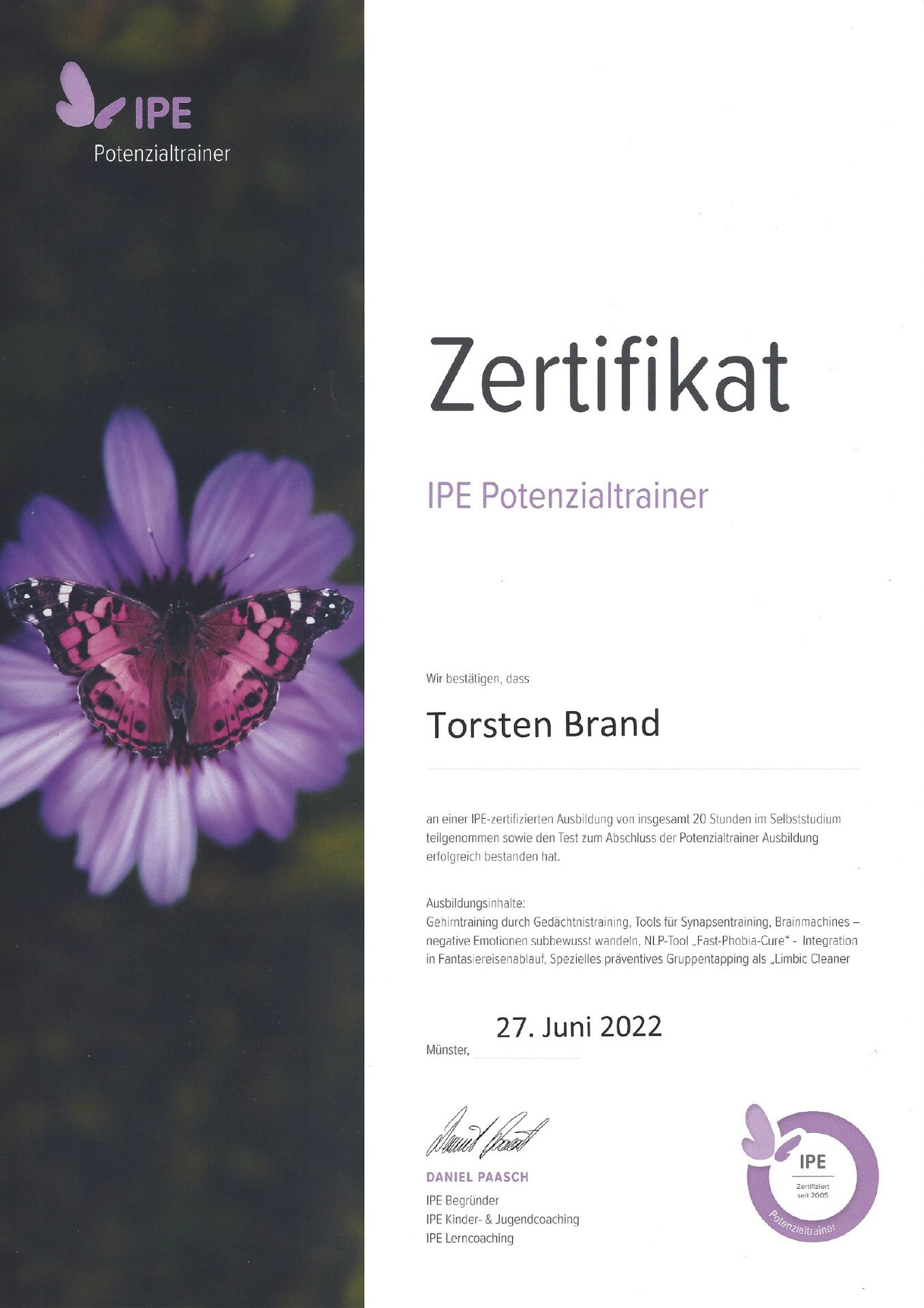 Eine Urkunde mit einer violetten Blume und einem Schmetterling darauf.