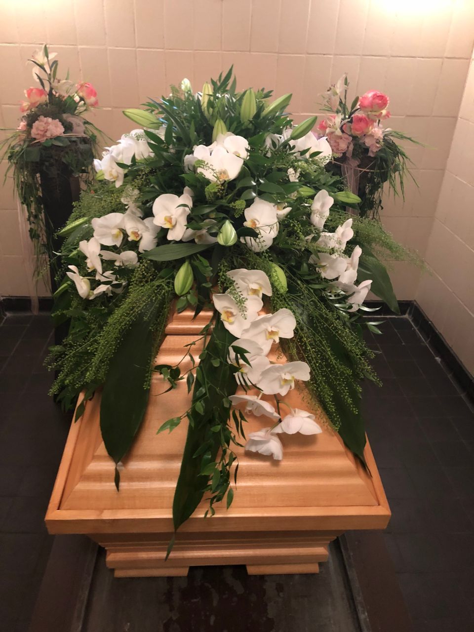Sargschmuck aus weißen Orchideen und Lilien