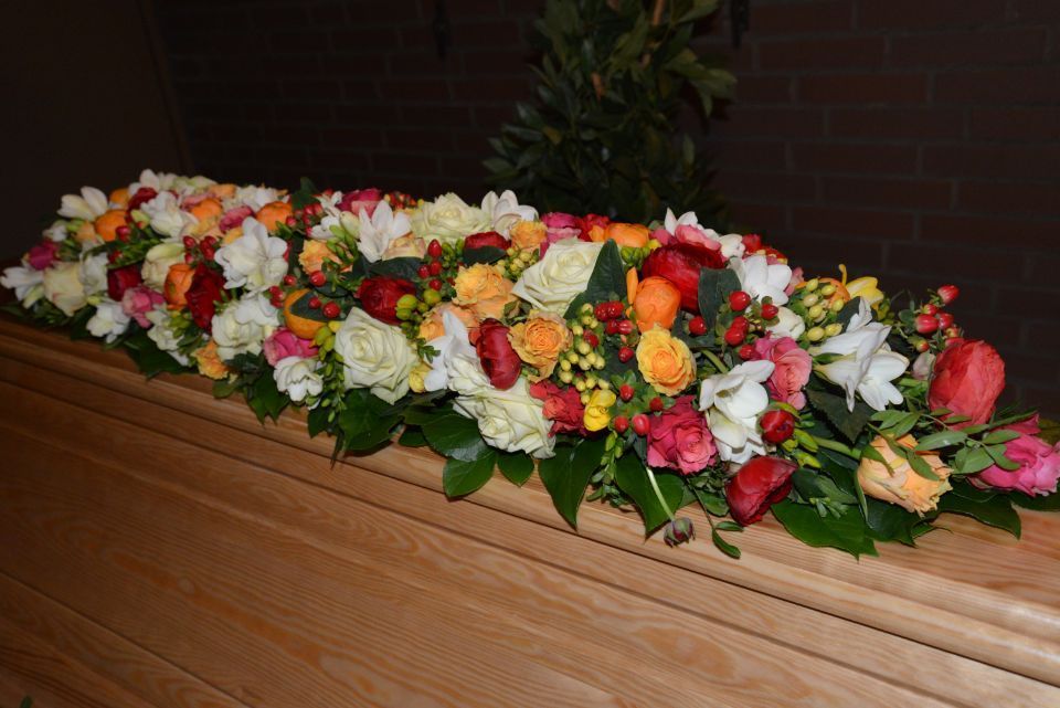 Sargschm Sargschmuck vor allem aus bunten Rosenuck aus weißen Orchideen und Lilien