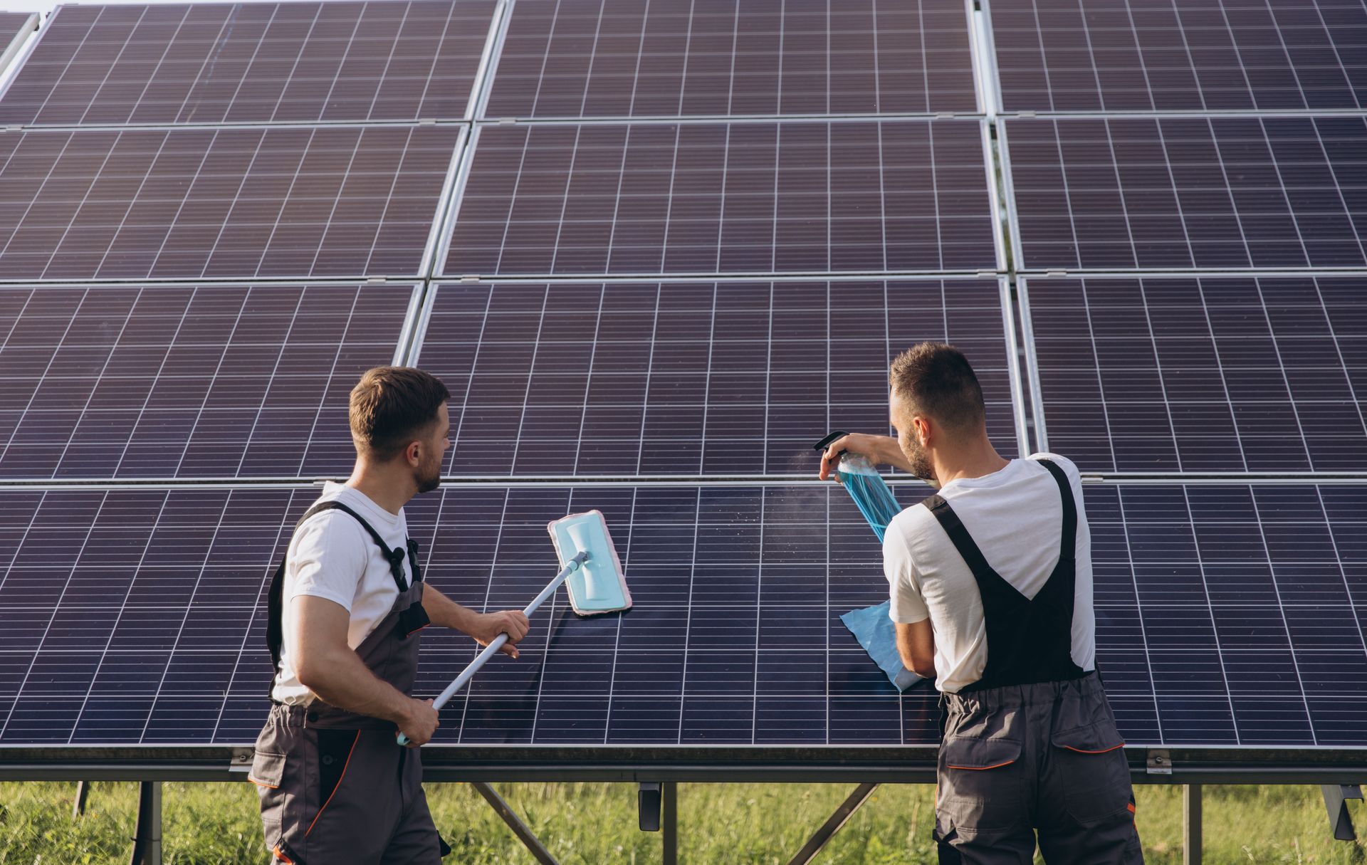 Zwei Techniker inspizieren Solarpaneele mit einem Tablet in einem Solarpark