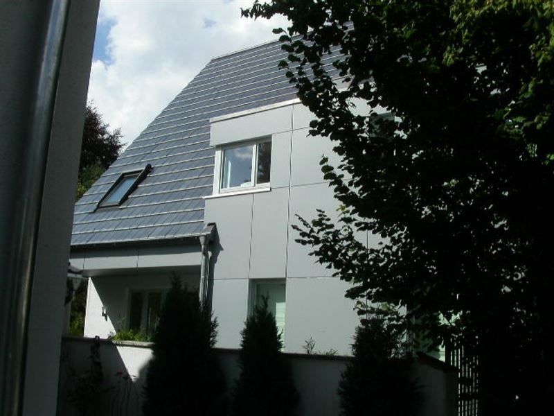 Ein Haus mit einem Dach, auf dem sich ein Oberlicht befindet