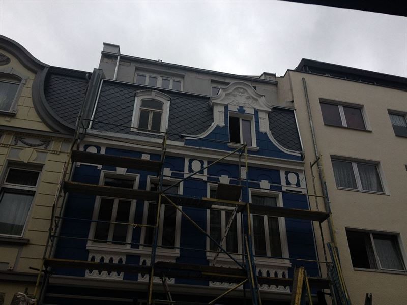 Ein blaues Gebäude mit einem Gerüst davor