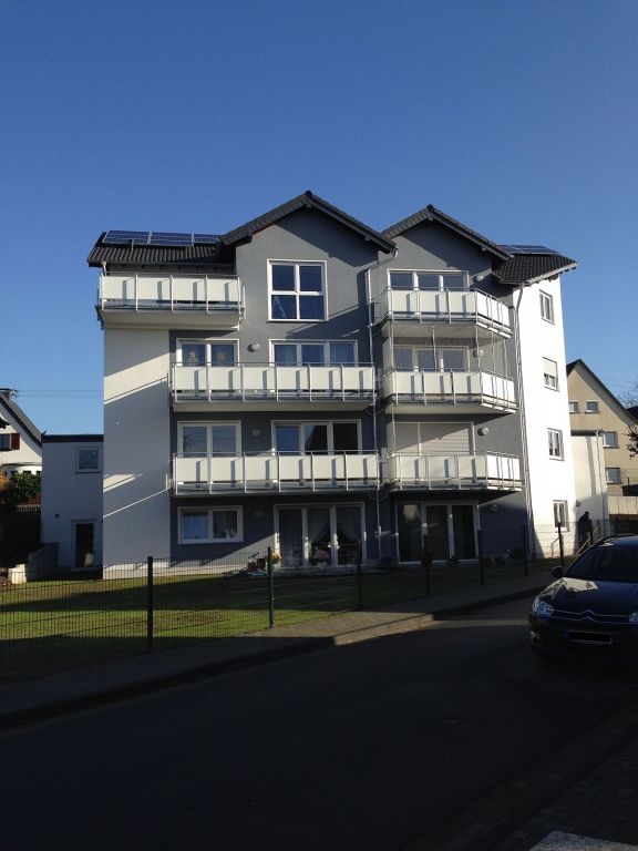 Ein Gebäude mit Balkonen und einem blauen Himmel im Hintergrund