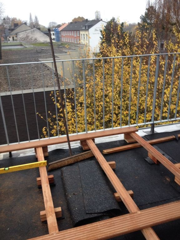 Auf einem Balkon wird eine Holzterrasse gebaut