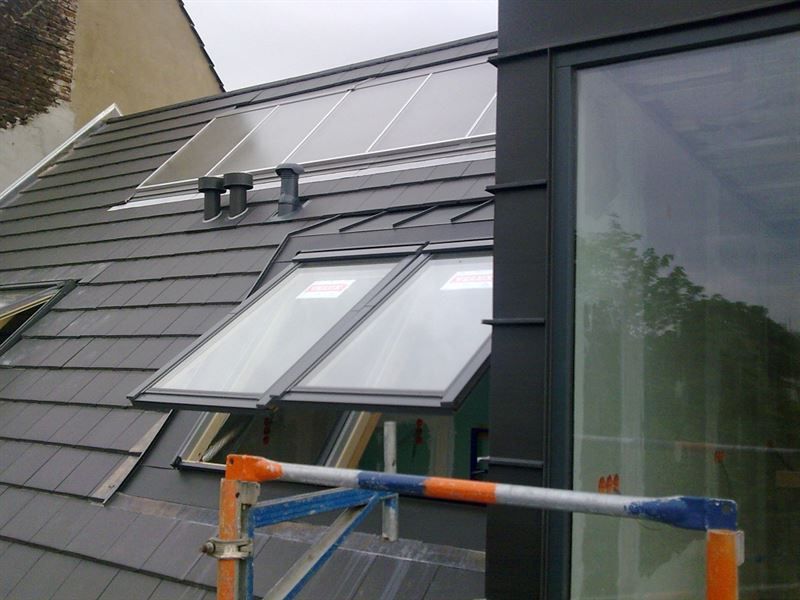 Ein Dach mit einem Fenster und Sonnenkollektoren darauf