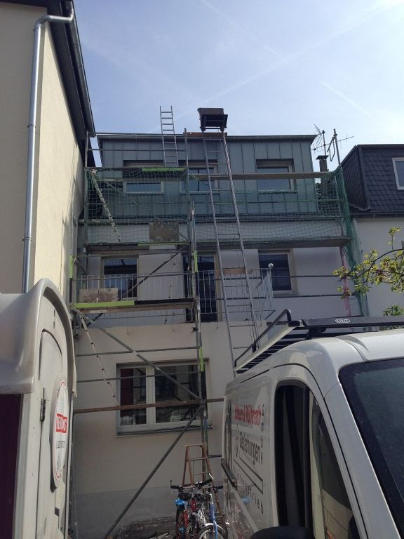 Ein weißer Lieferwagen steht vor einem im Bau befindlichen Gebäude