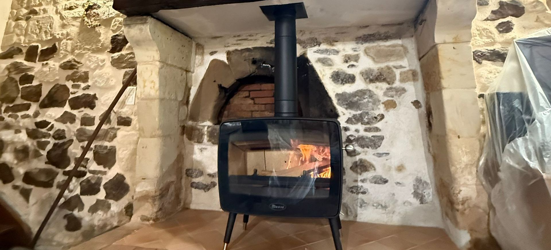 Un poêle à bois dans une pièce en pierre apparentes
