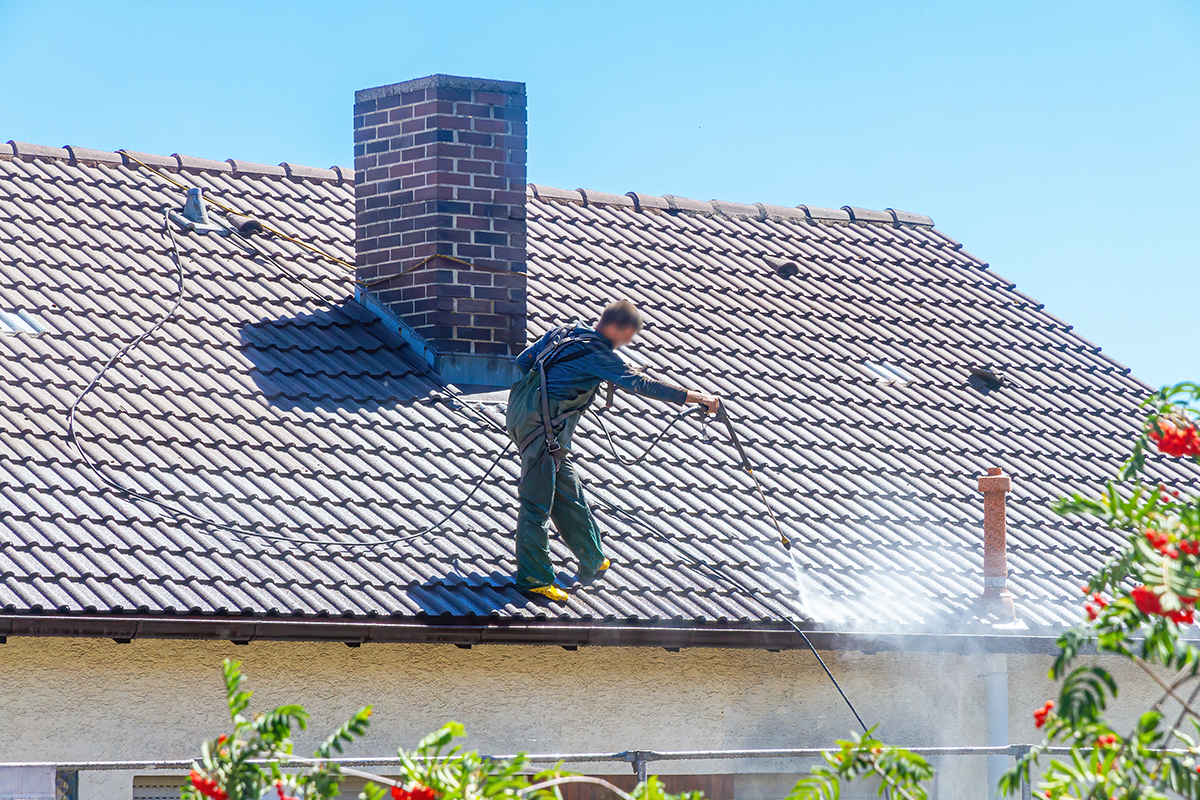 Un homme nettoie une toiture
