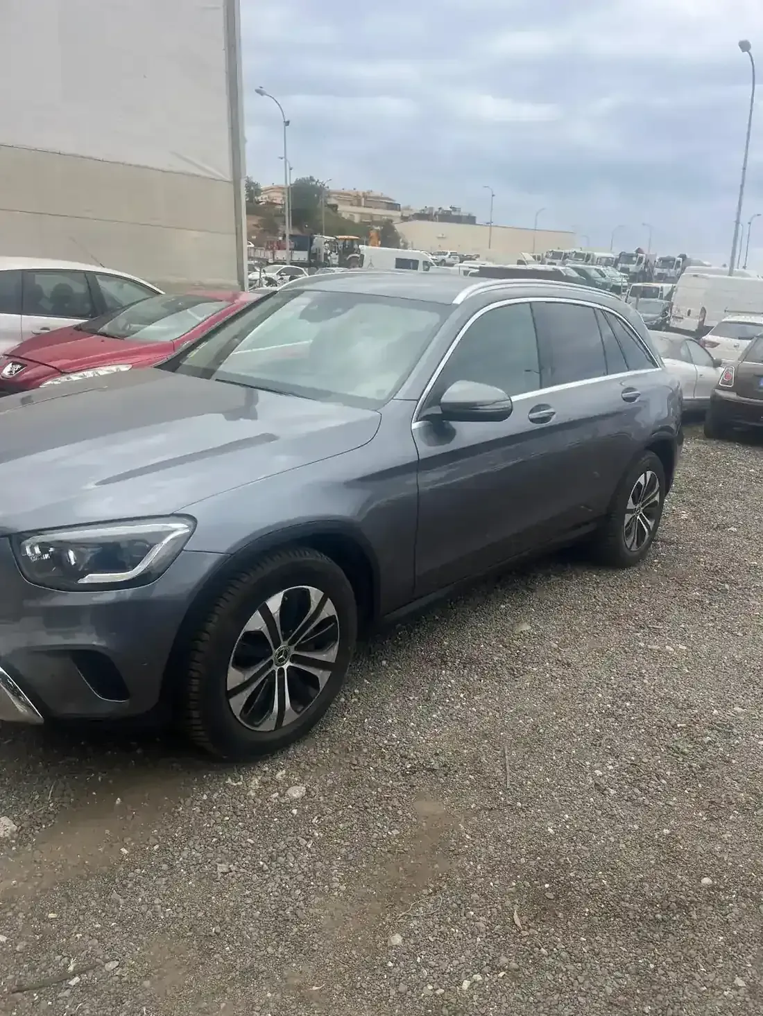 Una camioneta Mercedes-Benz de color gris con el capó abierto en un garaje, probablemente para reparaciones.