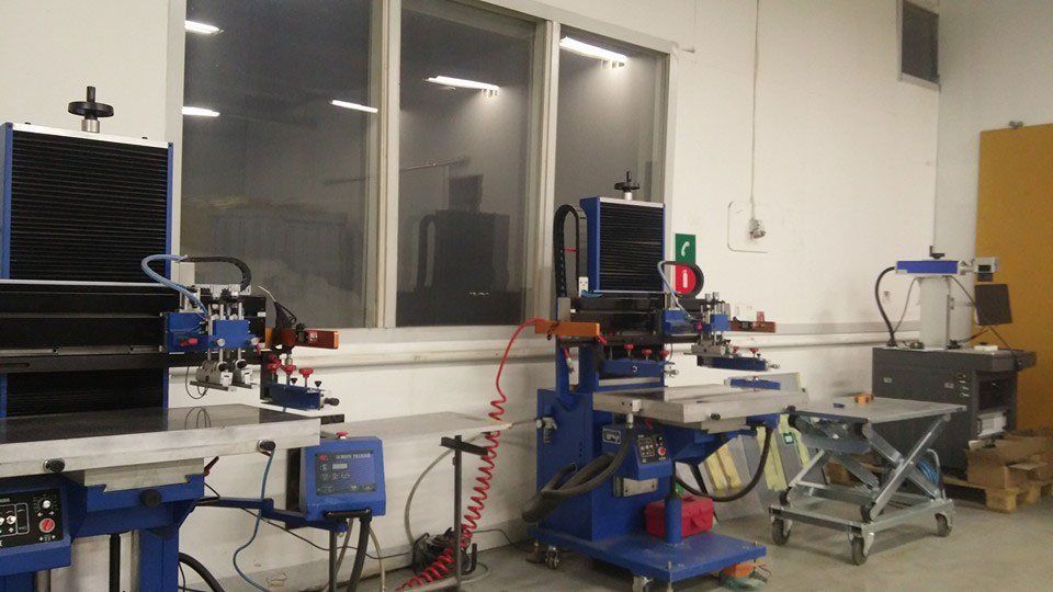 Silkkipainon painokoneet Laaksojen Laatupinnan työpajalla.