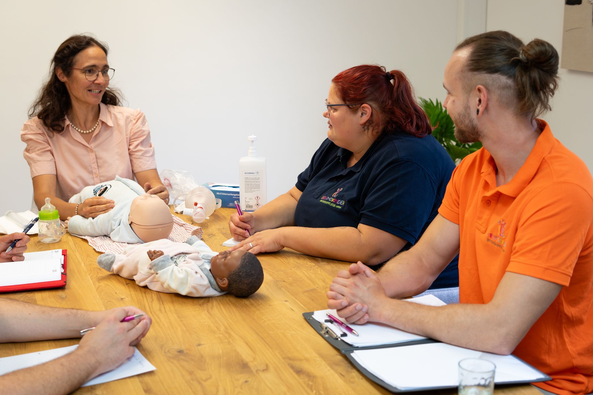 Ein Kind mit lockigem Haar betrachtet ein Buch, das von einer unsichtbaren Person an einem Tisch gehalten wird.