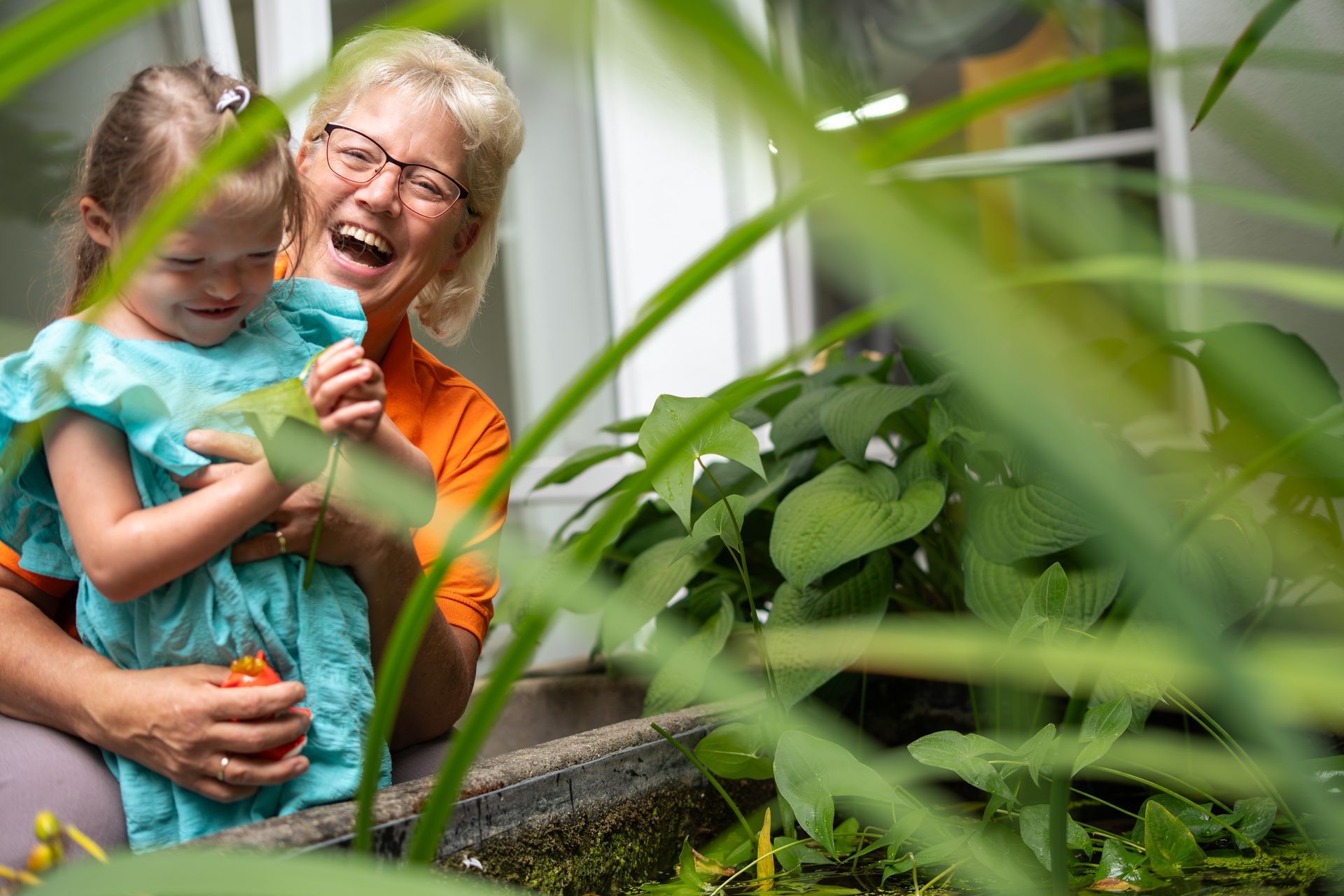 Krankenschwester hilft einem jungen Mädchen in häuslicher Umgebung beim Anlegen einer Inhalationsmaske.