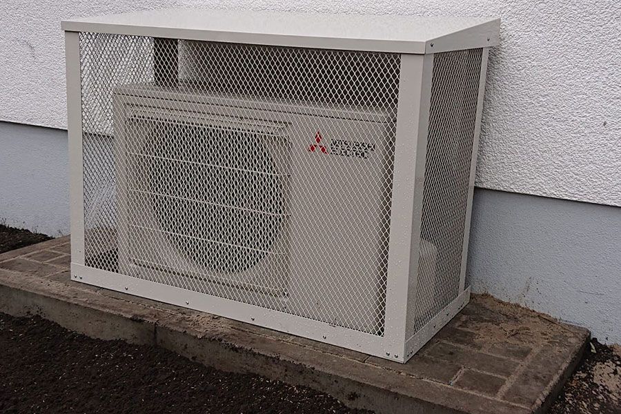 Eine Mitsubishi-Klimaanlage sitzt in einem Metallkäfig