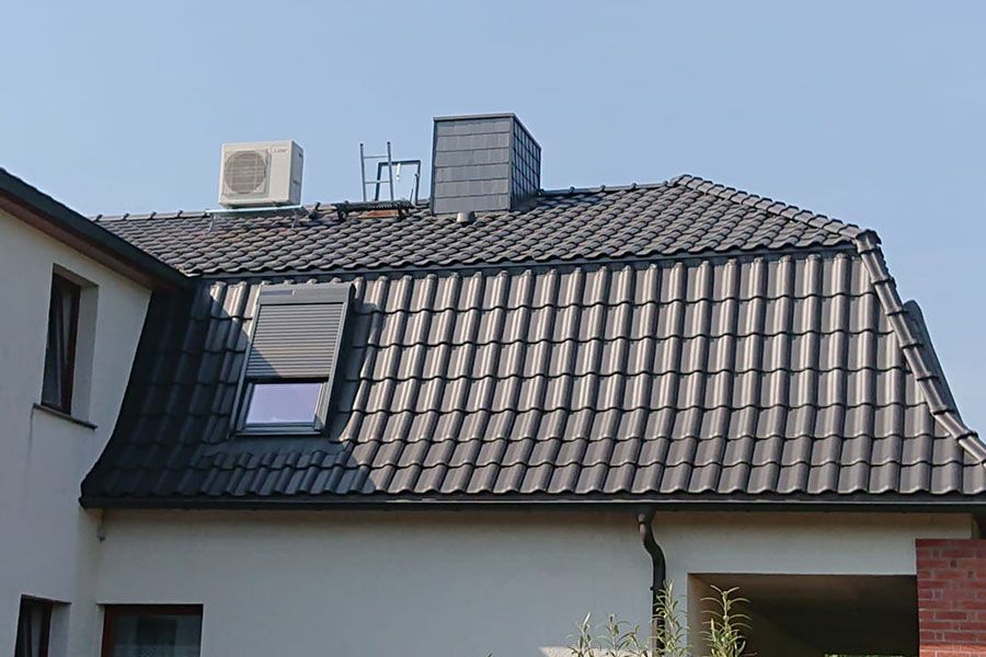 Ein weißes Haus mit einem schwarzen Dach und einem Fenster