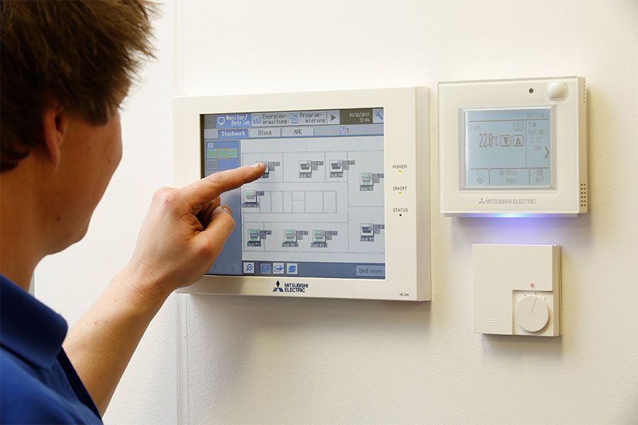 Ein Mann zeigt auf einen Bildschirm an einer Wand.