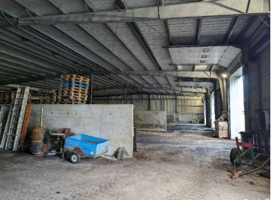 Toit de tuiles rouges sur un bâtiment avec deux puits de lumière sous un ciel nuageux.